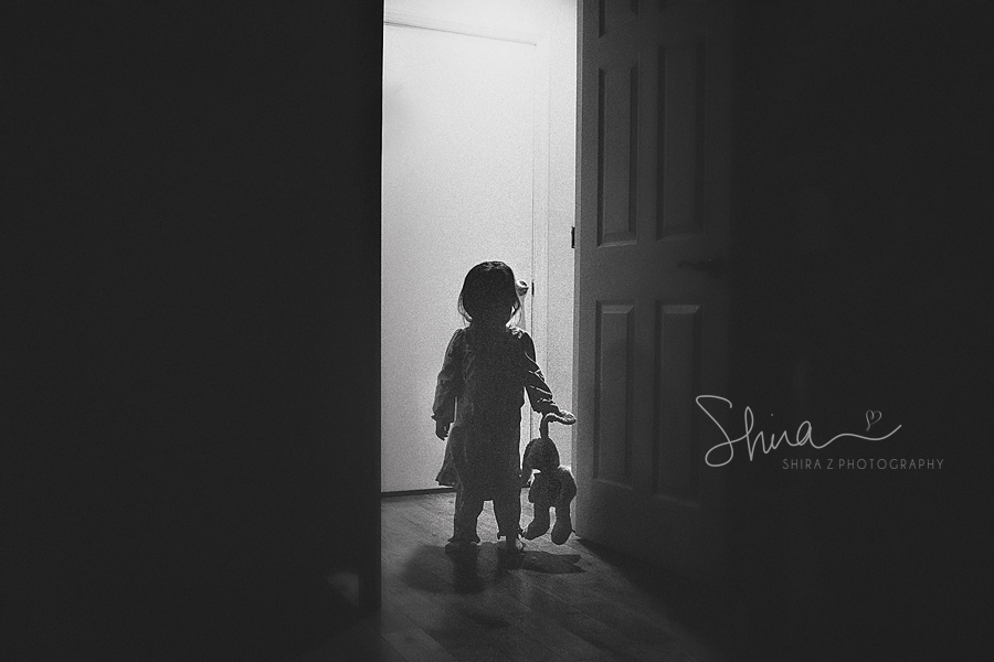 little girl getting ready for bed holding her bunny in shadow in Long Island, NY
