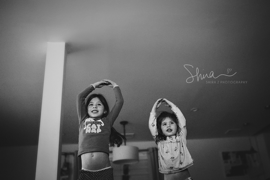 Sisters dancing with arms in the air, photographed by a Long Island Family Photographer