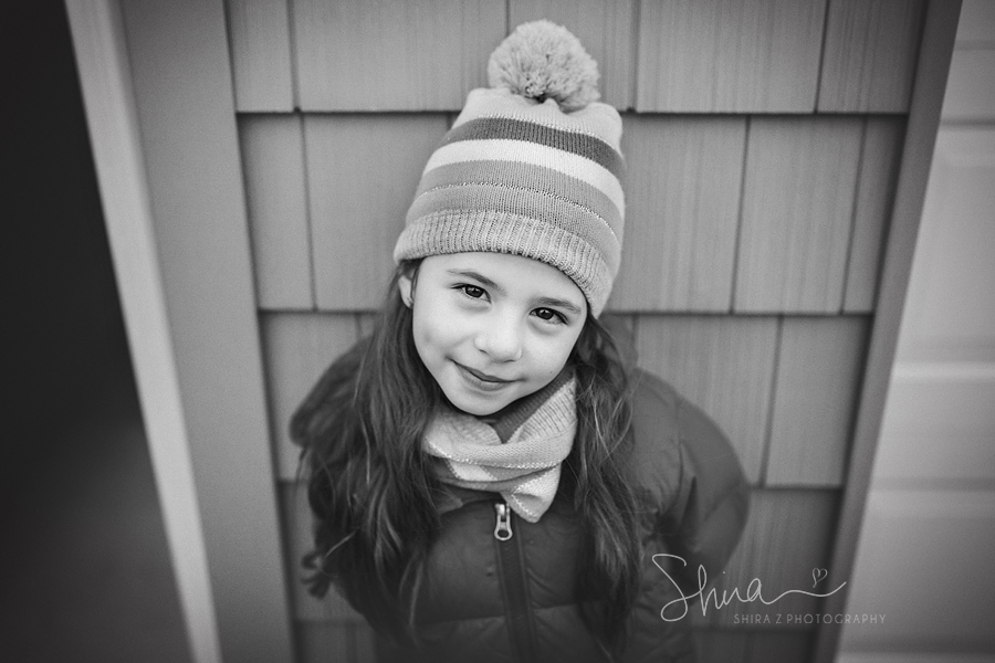 Six year old girl wearing a winter hat and scarf smiling for a Long Island Family Photographer