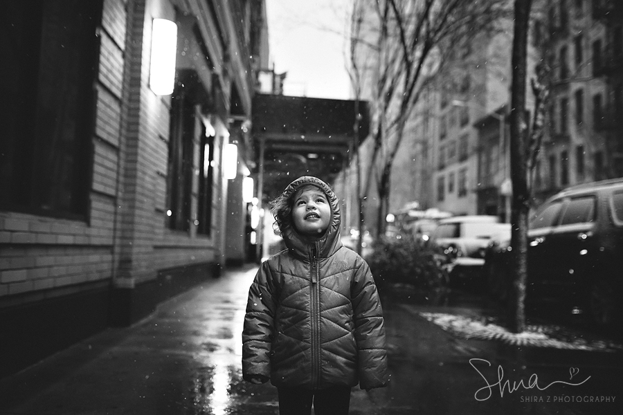 Photograph of a little girl standing in NYC with snow falling down
