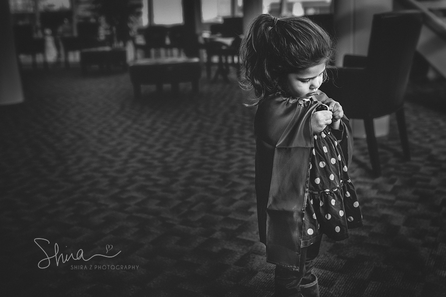 little girl putting on a cape at X-ray office in Long Island NY