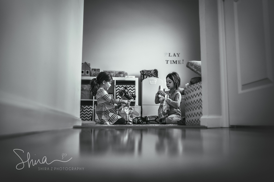 2 sisters playing with dolls in play room Long Island, NY